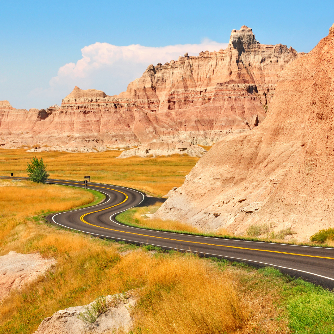 Badlands Loop Road winding through layered rock formations and prairie grasslands in Badlands National Park