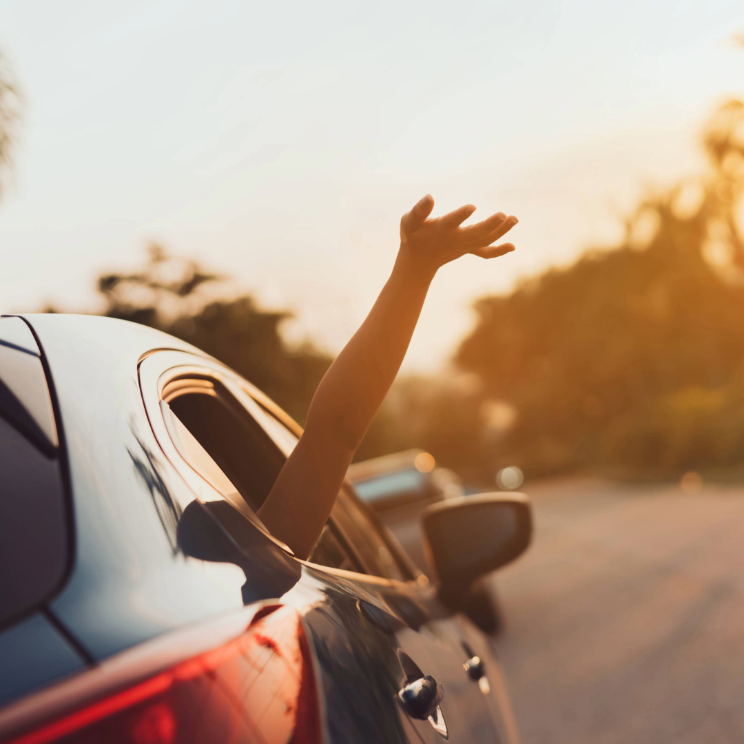 Arm out car window at sunset on open highway, capturing the freedom of spring break road trips Arm out car window at sunset on open highway, capturing the freedom of spring break road trips